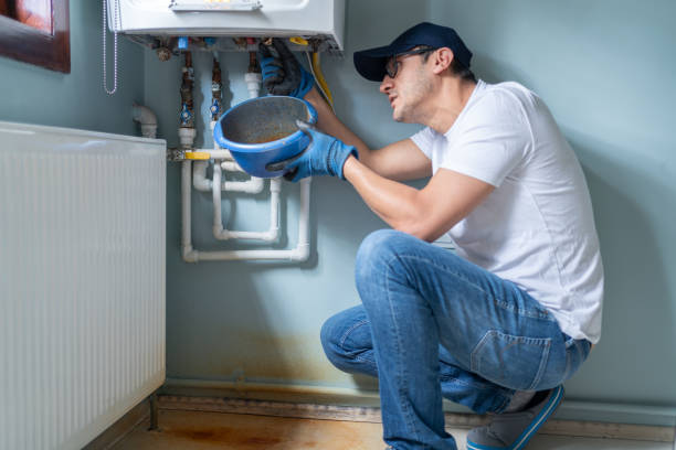 man looking at water leaking from broken natural gas combi boiler